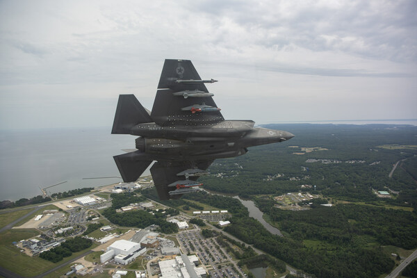 F-35 flying through sky overlooking landscape